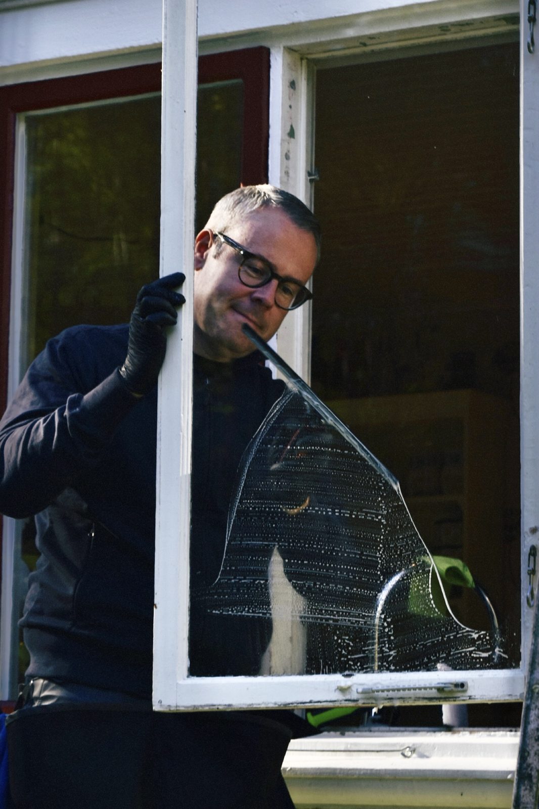 Daniel putsar en fönsterbåge med skrapa